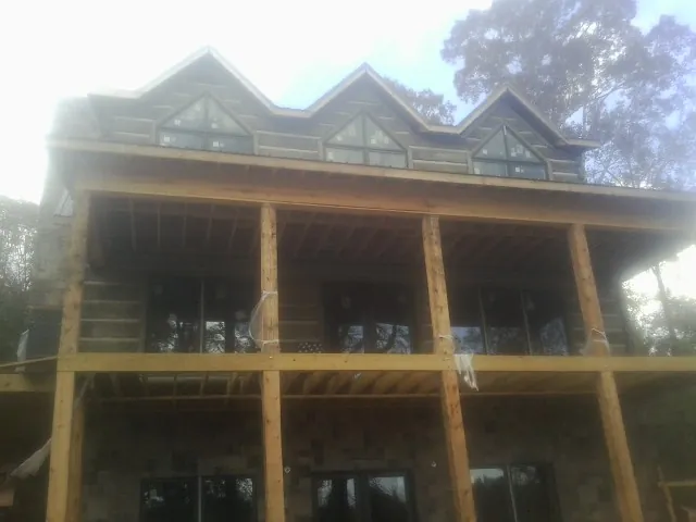 Dormers and porch framing on a large log home under construction — Roof Coating work by our crew in Paradise